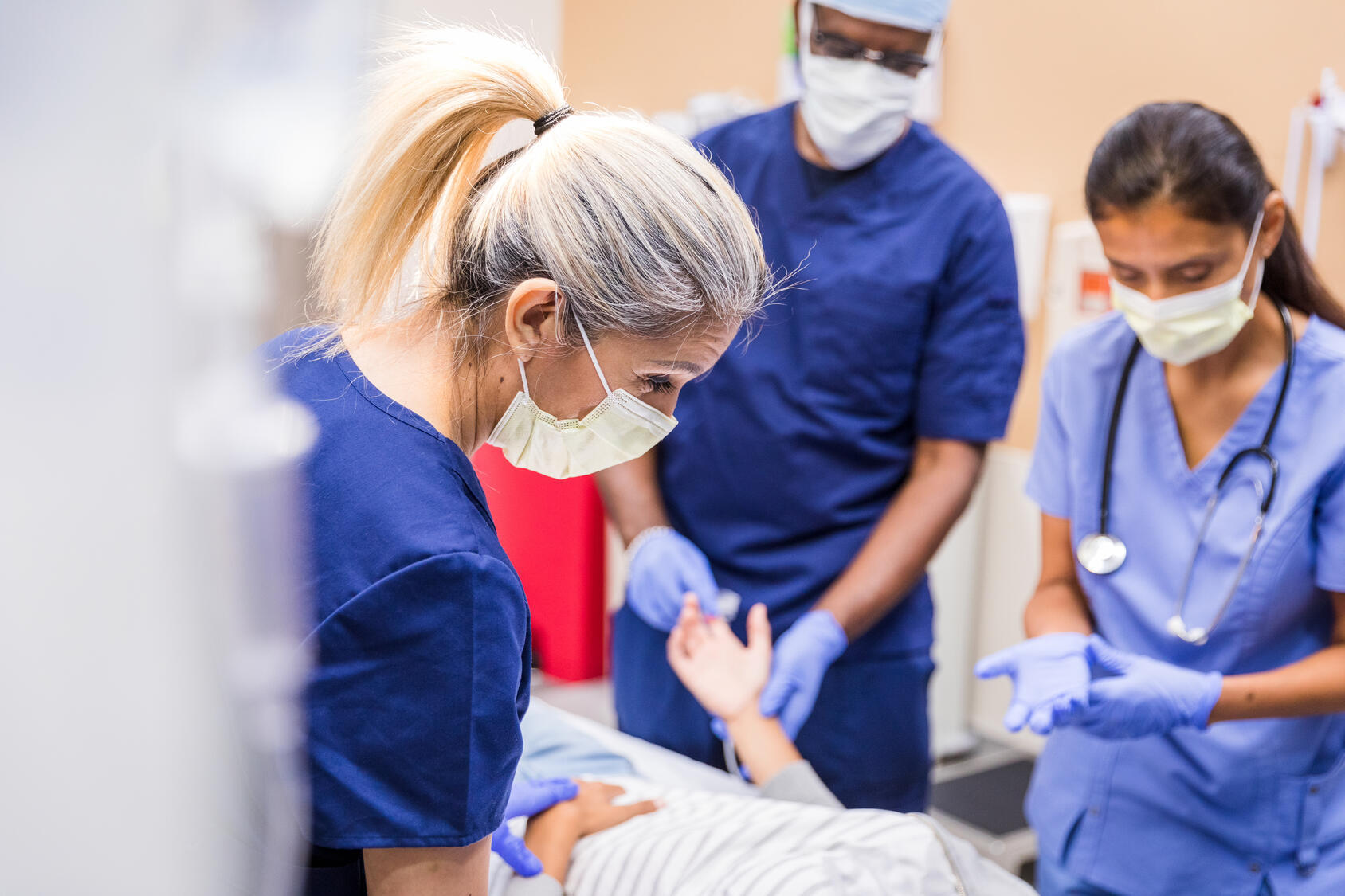 Nurses working together to care for a patient during a hospital visit.